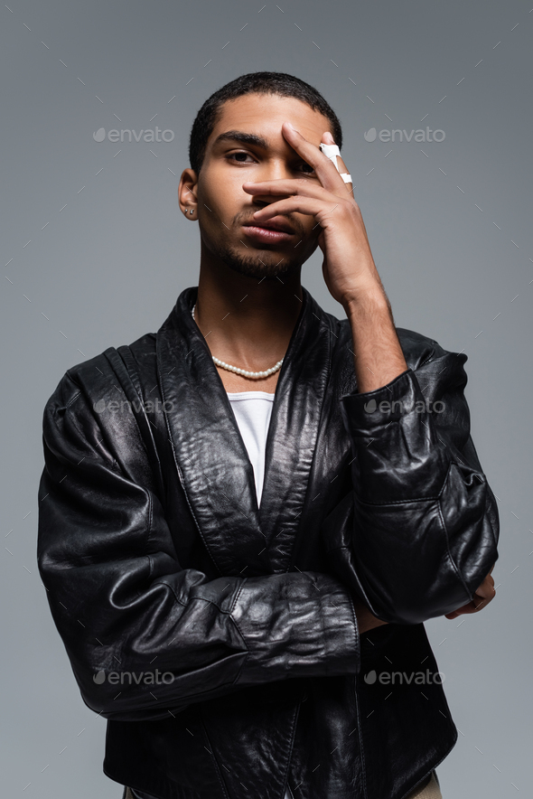 young african american man in leather jacket covering face