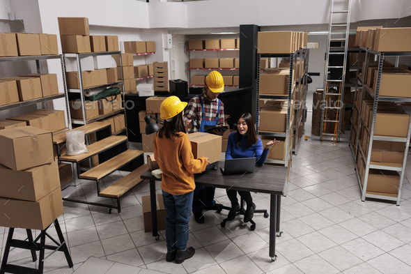 Warehouse package handlers doing inventory control with logistics manager