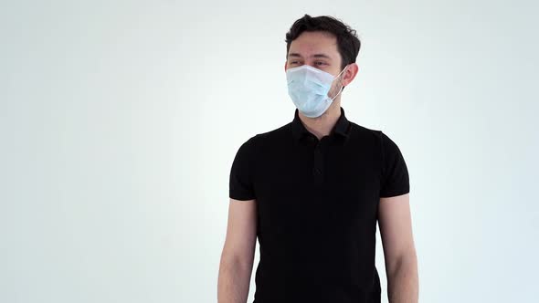 Portrait of Young Confident Man Wearing Protective Mask Takes Off His Mask. alt
