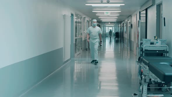 Hospital Hallway with Medical Workers Walking Through It alt