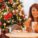Woman eating gingerbread cookies while spending Christmas day at home - PhotoDune Item for Sale