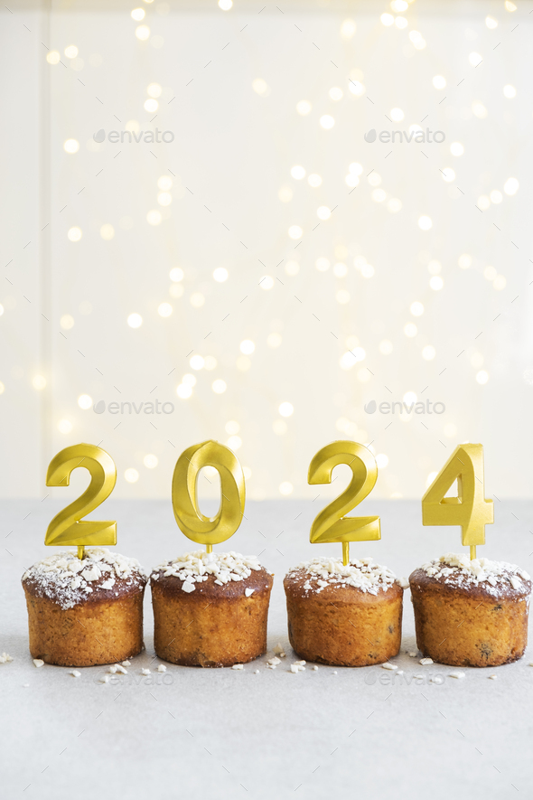 Golden candles with 2024 number on top of cupcakes Stock Photo by ta_bu