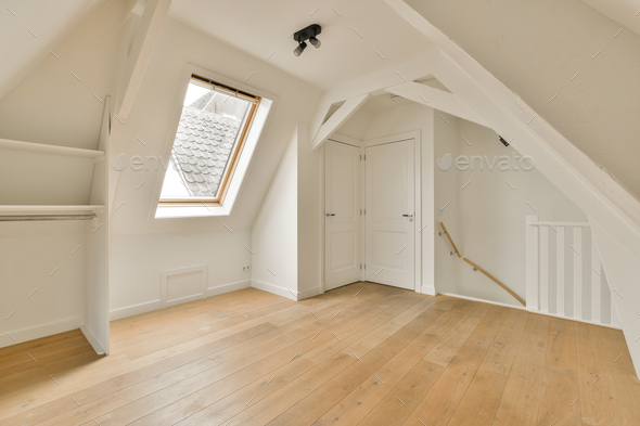 a loft conversion with white walls and wooden flooring
