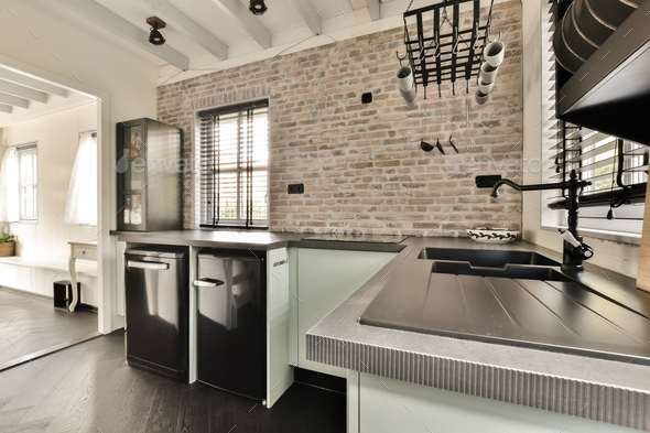 a kitchen with a sink and a brick wall