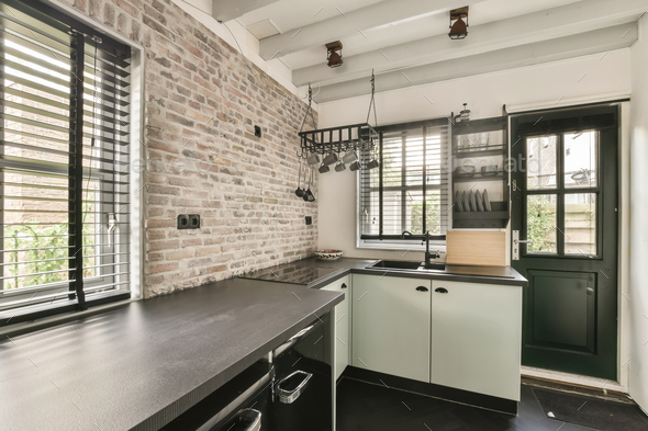 a kitchen with a brick wall and a large counter