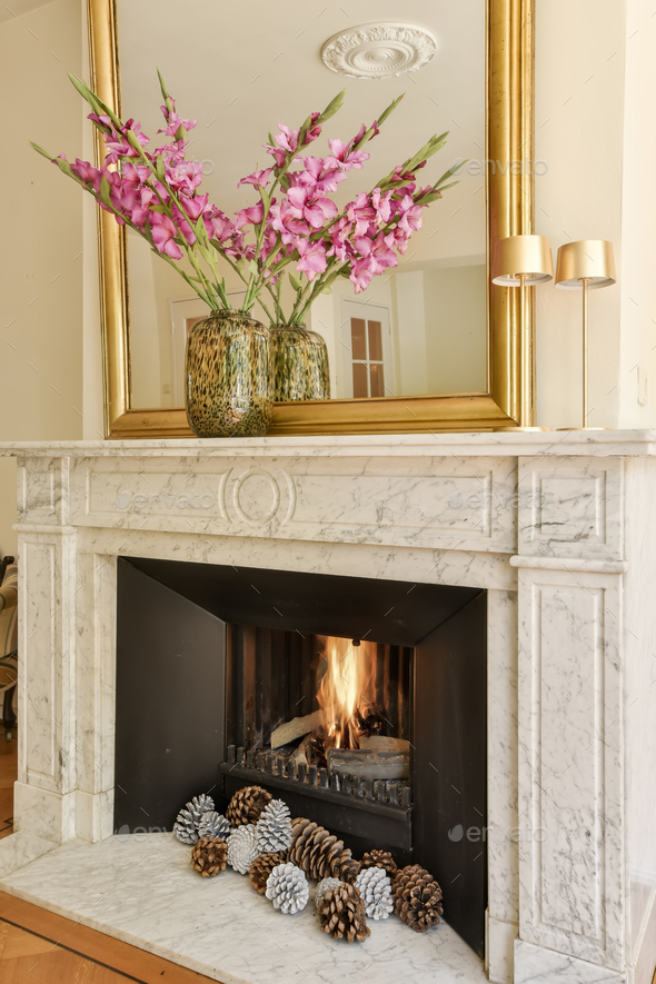a fireplace mantel with pine cones and a mirror