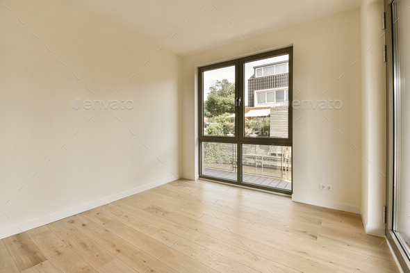 a living room with a large window and wooden floors