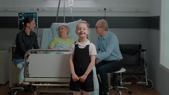 Portrait of Child Visiting Senior Woman in Hospital Ward with Mother alt