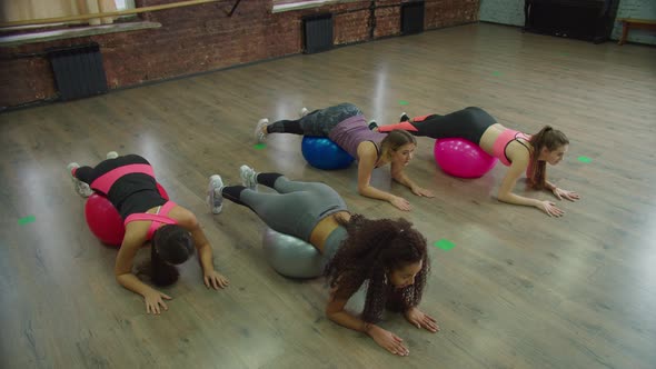 Fit Females Exercising Reverse Leg Raise on Swiss Ball alt