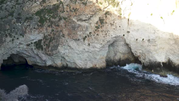 Caverns of Blue Grotto with Cold Blue Mediterranean Sea Waves Crashing in Stones