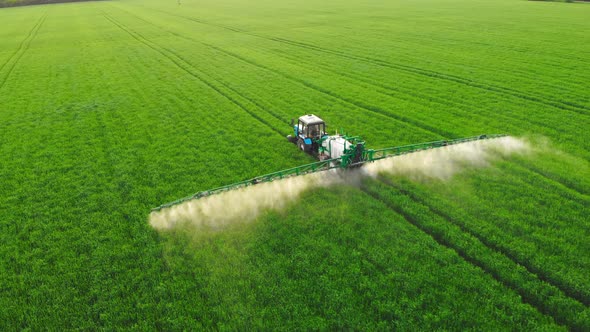 Aerial Top View of Farming Tractor Plowing and Spraying on Agriculture Large Territory Greenfield alt