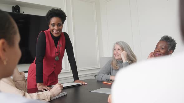 Slow motion of mature black woman holding business meeting with multi ethnic colleagues alt