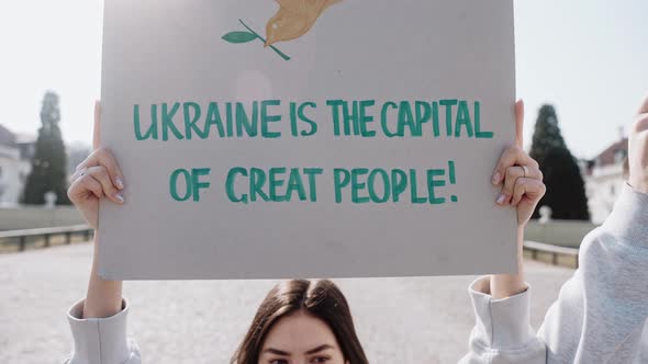 A Woman Holds a Poster with the Quote Against War in Ukraine