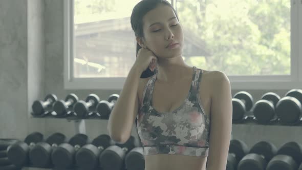 Beautiful young asian woman after workout with tired and exhausted in the gym. alt