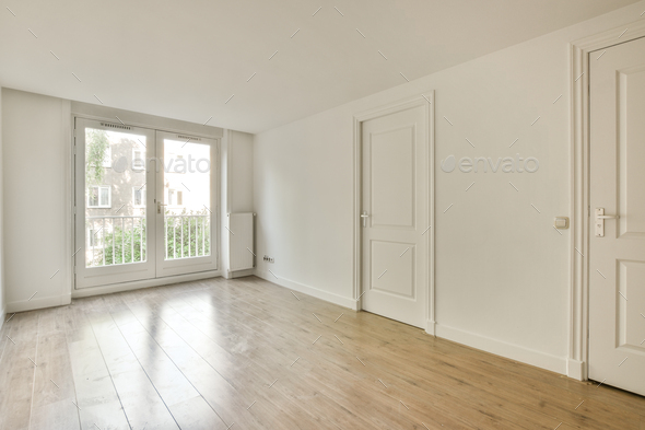 an empty living room with white walls and a door