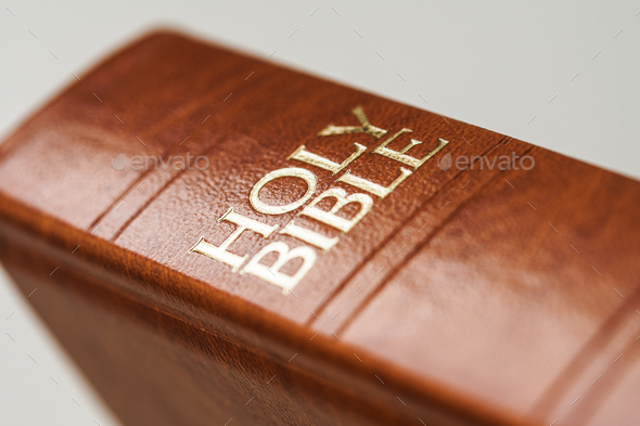 A close-up photo of a leather cover holy bible book with white background