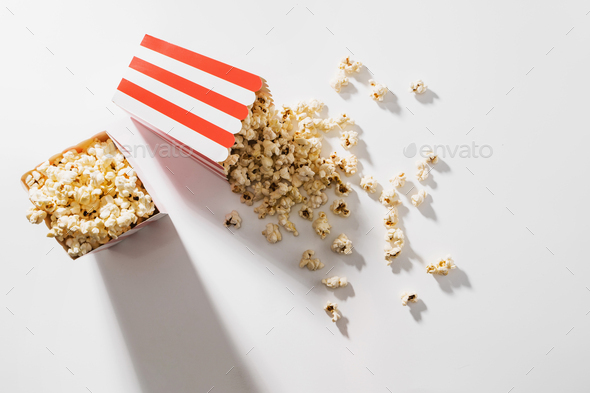 Classic striped buckets with delicious popcorn on white background