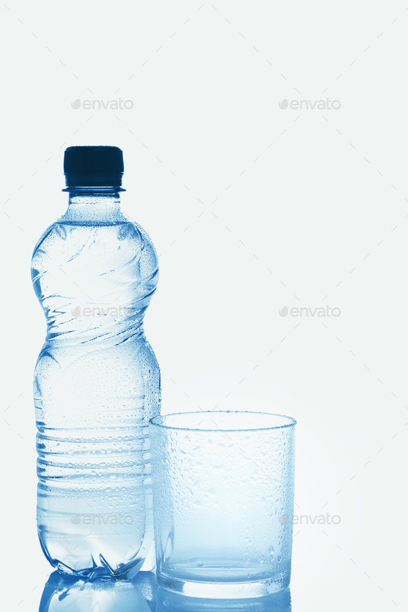 Blue bottle of pure still water and wet glass against white background ...