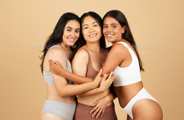 Three diverse women embracing, showcasing beauty in simple
