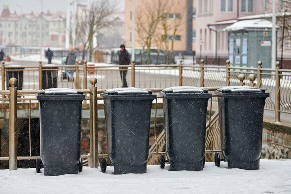 Grey garbage bins, trash containers outdoors in winter