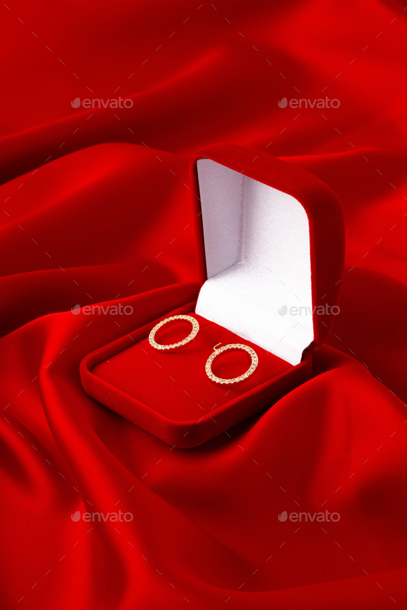 Hoop earrings in box on red silk background