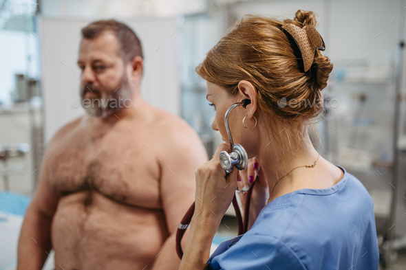 Female doctor listening to heartbeats and rhytm of overweight patient using stethoscope, detecting
