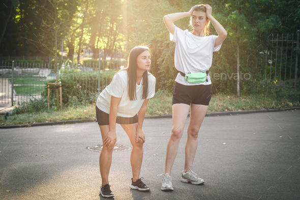 Two young adult woman running in a park. Stock Photo by puhimec