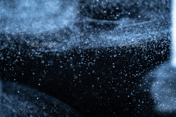 Blue particles on black background with cinematic atmosphere. Glittering sparkling bokeh overlay.