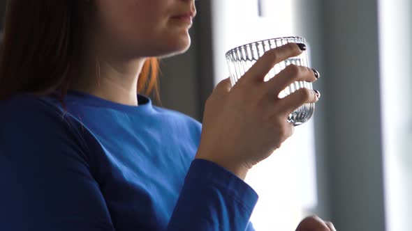 Woman in Kitchen Drinks From a Glass Clean Water Useful for Health Looks Ahead