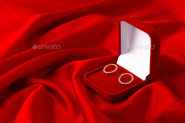 Hoop earrings in box on red silk background