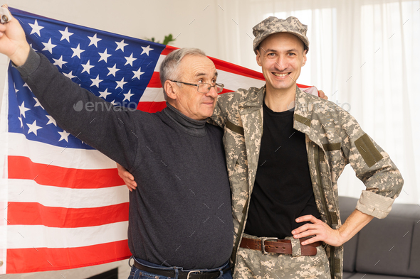 an elderly father and a military son saluting American flag