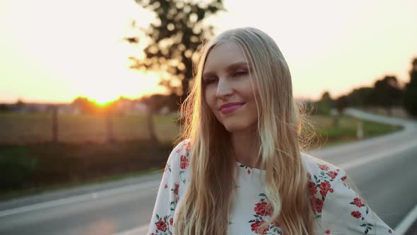 Young Female with Red Suitcase Standing on Roadside and Hitchhiking While Travelling Through alt
