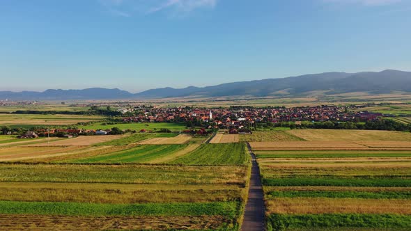 Flying towards Sancraieni, idyllic European village among farmland, Romania alt