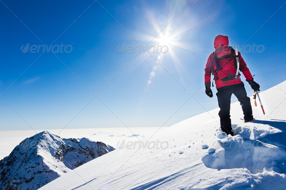 Mountaineer reaches the top of a snowy mountain in a sunny winter day. Western Alps, Biella, Italy. - Stock Photo - Images