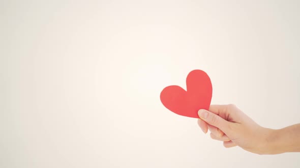 Red Paper Valentine in a Woman's Hand on a White Background alt