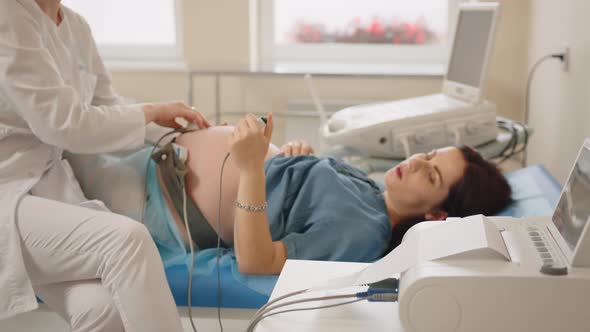 Gynecologist Checking Fetal Heartbeat of Pregnant Woman alt