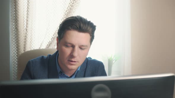 Man Using Nasal Medicine While Working at Computer alt