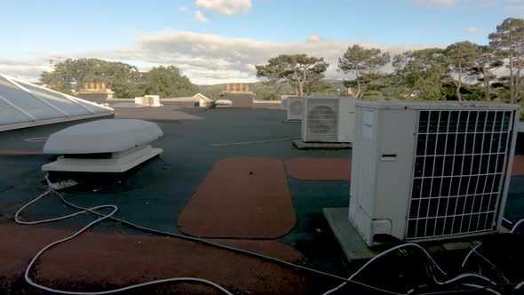Air Compressor on Roof of Building with Blue Sky and Clouds Time Lapse alt
