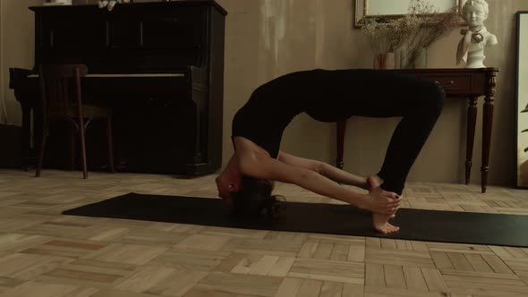 Woman Performs a Bridge Element on a Yoga Mat