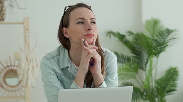 Young Woman Working Using Laptop with Hand on Chin Thinking Pensive Expression alt