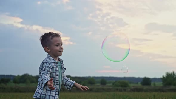Slow Motion Video of a Boy Bursting Soap Bubbles alt
