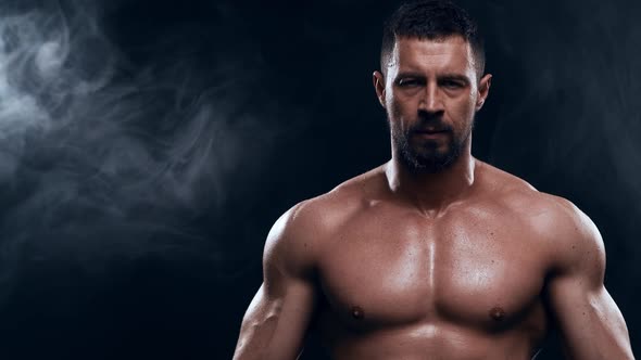 Fit and sporty bodybuilder over black background. alt