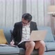 Asian Businessman In Jacket And Shorts Writing In A Notebook While Working With A Laptop At Home - VideoHive Item for Sale