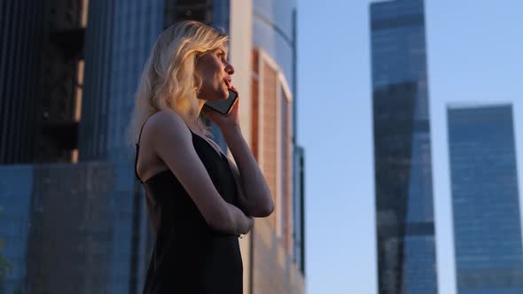 stylish woman talking on the phone on the background of skyscrapers