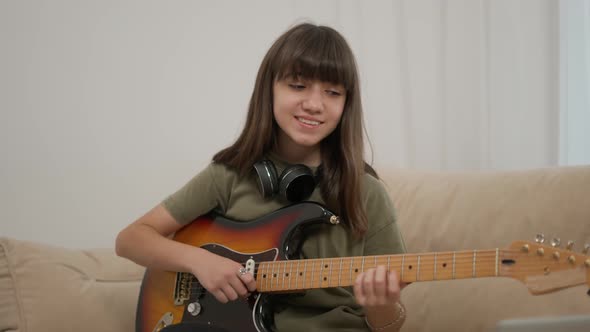 Cheerful Teen Girl Learns to Play the Guitar alt
