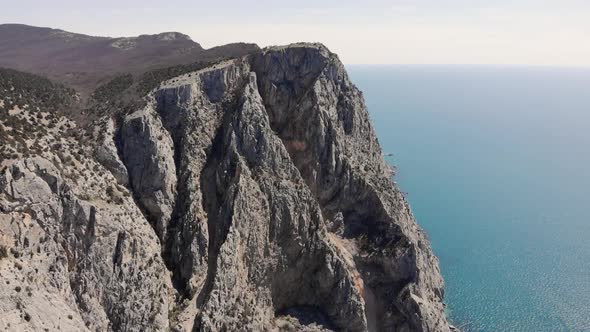 Aerial Top View of Waves Break on Rocks in a Blue Ocean