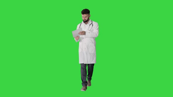 Doctor Reading Medical Report of Patient While Walking on a Green Screen, Chroma Key alt