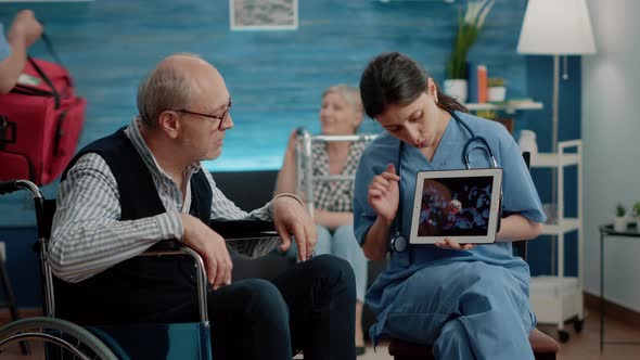 Patient with Disability Looking at Virus Animation on Digital Tablet alt