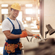 Cheerful male builder using professional equipment in workshop - PhotoDune Item for Sale