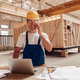 Cheerful male builder talking on cellphone at work - PhotoDune Item for Sale
